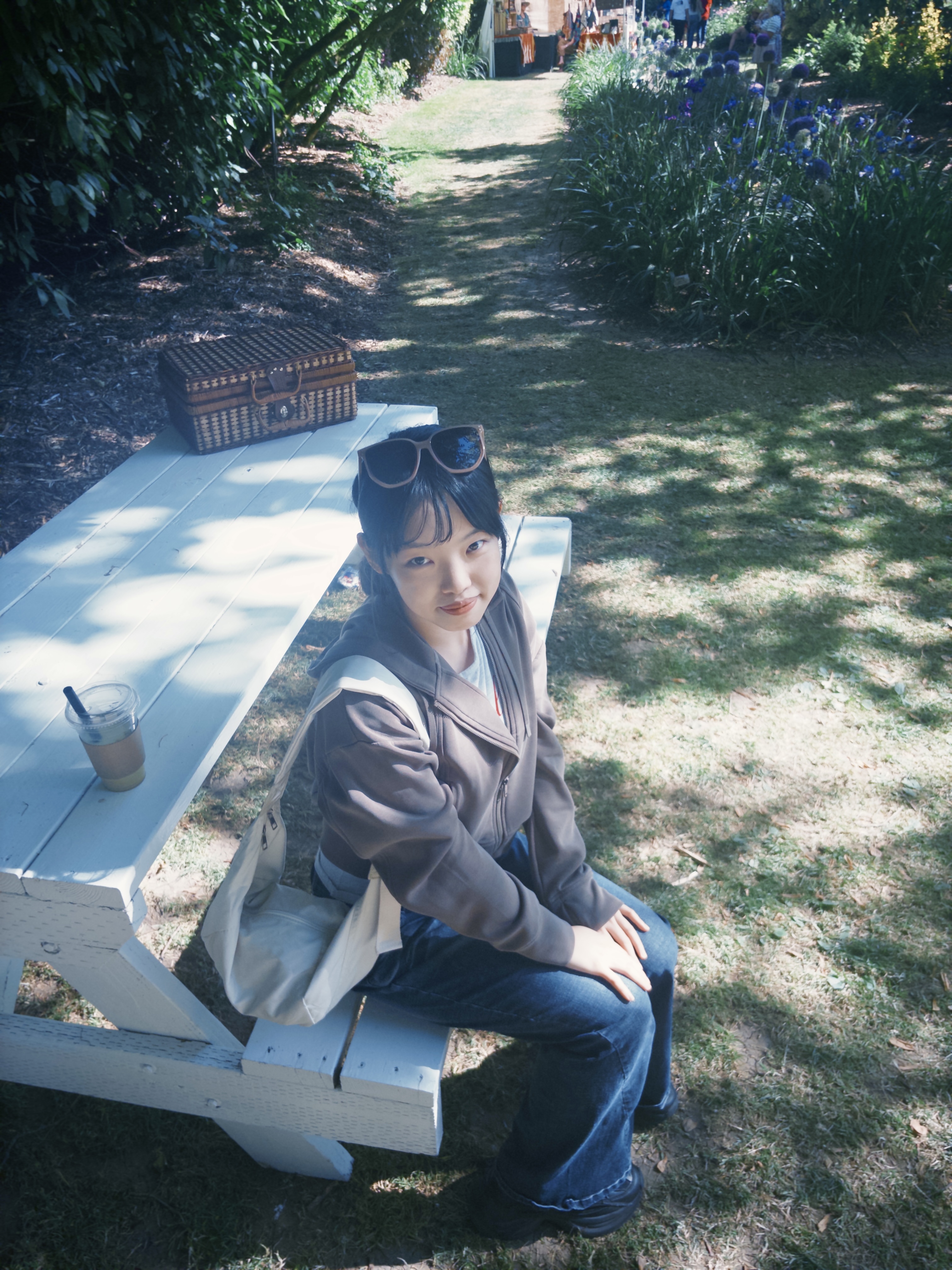 Junxin Liu seated outdoors at a picnic table